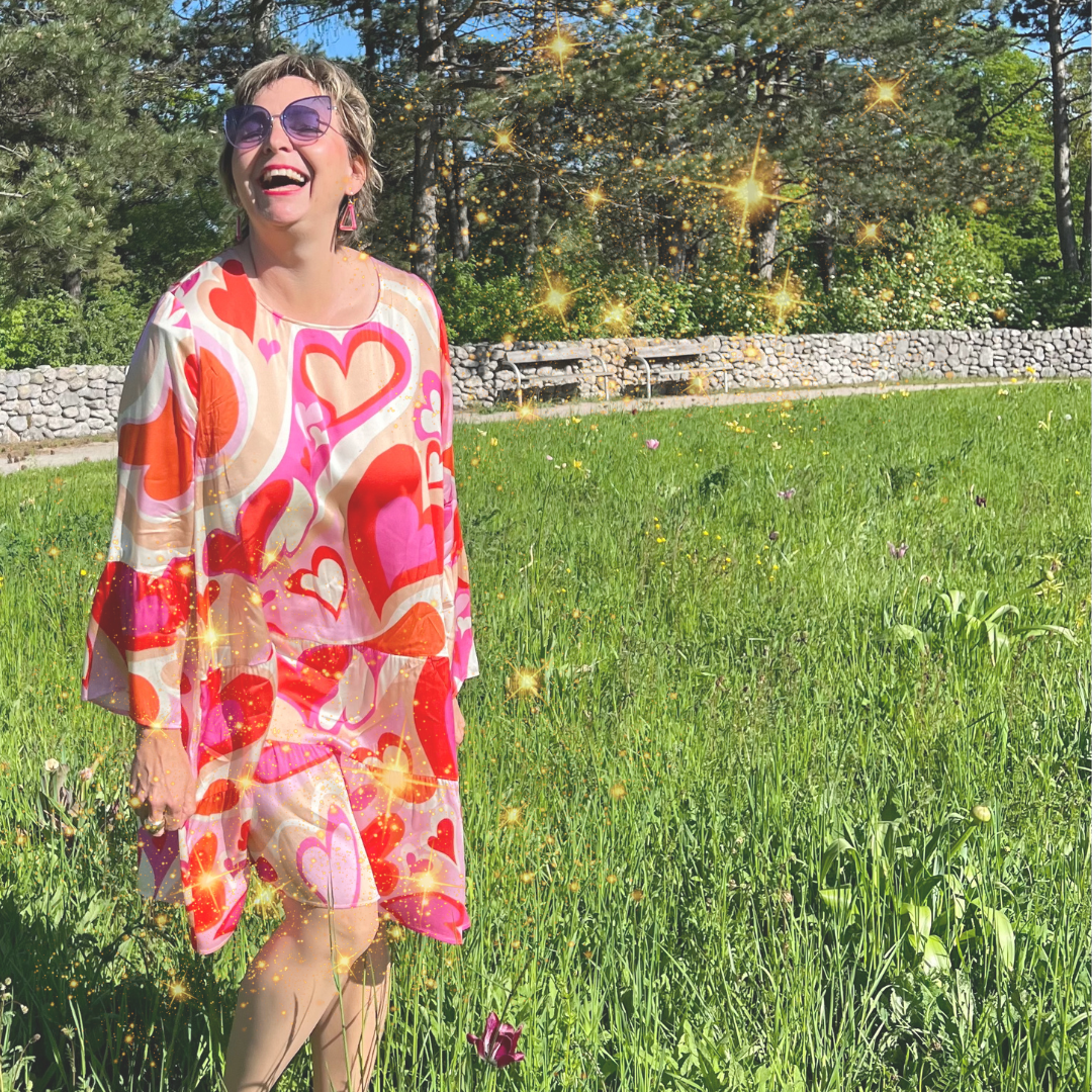 Christiane Leimer tanz und singt auf grüner Wiese mit einem pinken Kleid